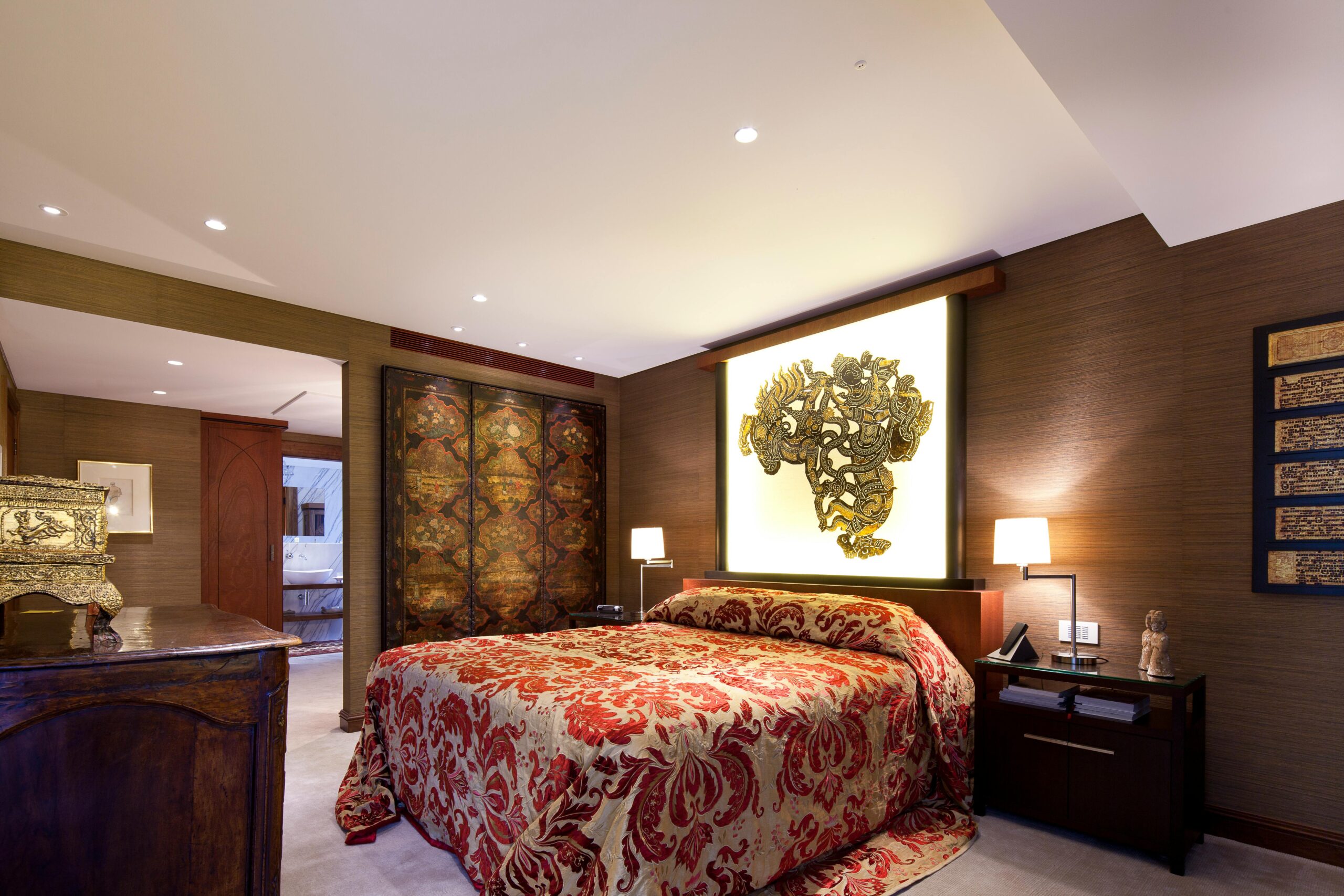 Elegant bedroom interior featuring ornate decor and warm lighting.