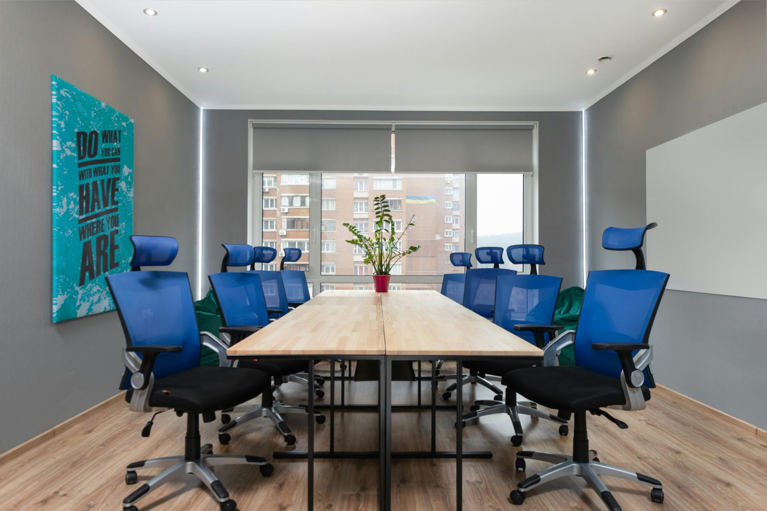 Contemporary office space with blue chairs, table, and motivational quote on the wall.